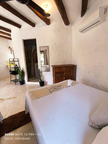 a bedroom with a white bed and a wooden dresser at Arte Sano Hotel Only Adults - Near Beach in Holbox Island