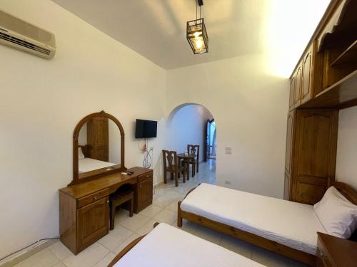1 dormitorio con 2 camas, espejo y escritorio en Red oasis, en Dahab
