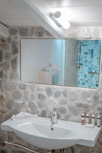 a bathroom with a sink and a large mirror at Alika Resort in Álika