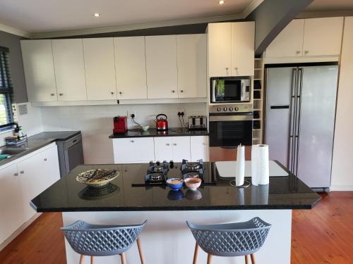 a kitchen with white cabinets and a black counter top at Riverview House Sedgefield in Sedgefield