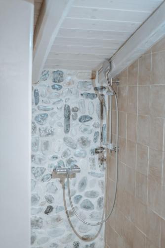 a bathroom with a shower with a stone wall at Alika Resort in Álika