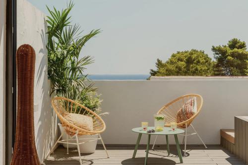 a patio with two chairs and a table on a balcony at Nativo Hotel Ibiza in Santa Eularia des Riu