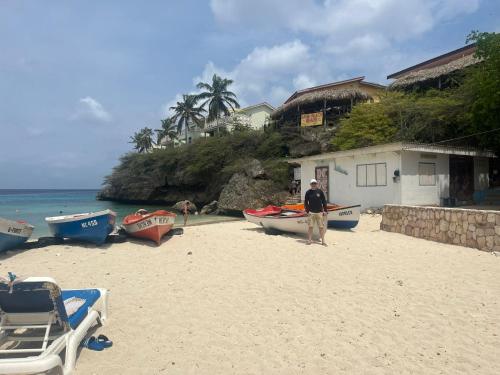 a man standing on a beach next to boats at Apartment "Always SUNday", Lagoon Ocean Resort in Lagun