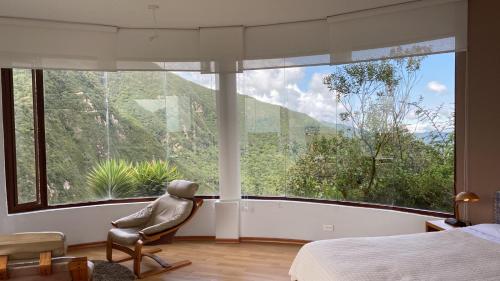 a bedroom with a chair in front of a large window at El Crater in San Antonio