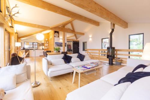 a living room with white furniture and wooden ceilings at Chalet Olbios in Peisey-Nancroix