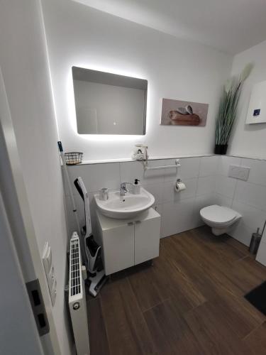 a white bathroom with a sink and a toilet at Ferienzimmer in Euskirchen in Euskirchen