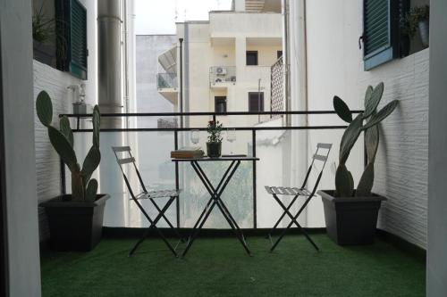 a balcony with a table and two chairs and plants at RUDIAE Palace In Lecce in Lecce