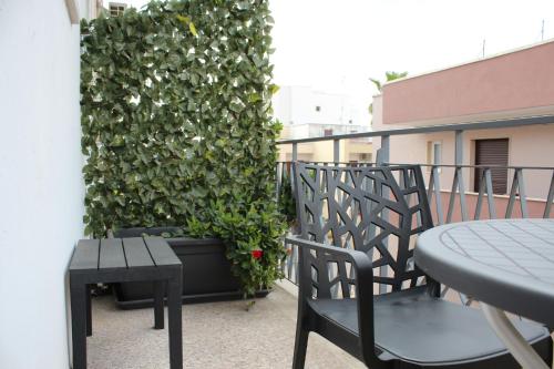 a balcony with two chairs and a table and a green wall at B&B DEGLI ANGELI in Lecce