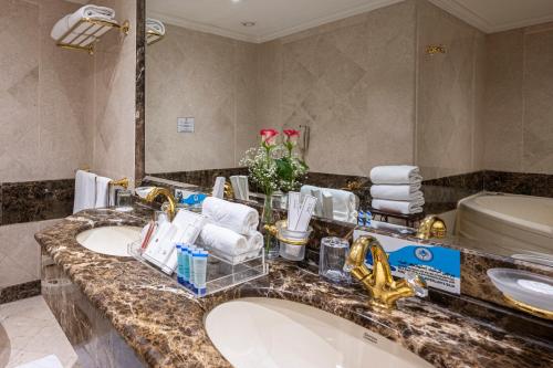 فندق الشهداء  في مكة المكرمة: حمام به مغسلتين ومرآة كبيرة