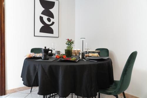 a table with a black table cloth and green chairs at RUDIAE Palace In Lecce in Lecce