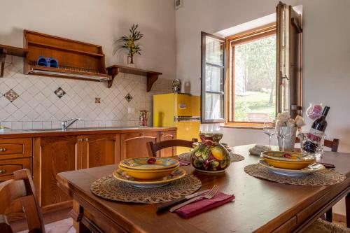 a kitchen with a wooden table with dishes on it at Podere Marcigliana in Radicondoli