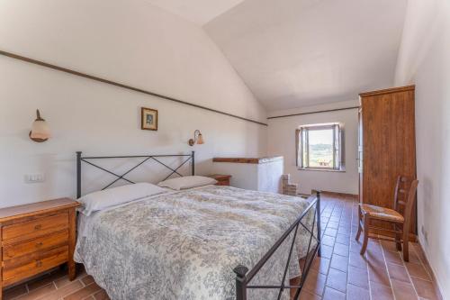 a bedroom with a bed and a table and a chair at Podere Marcigliana in Radicondoli