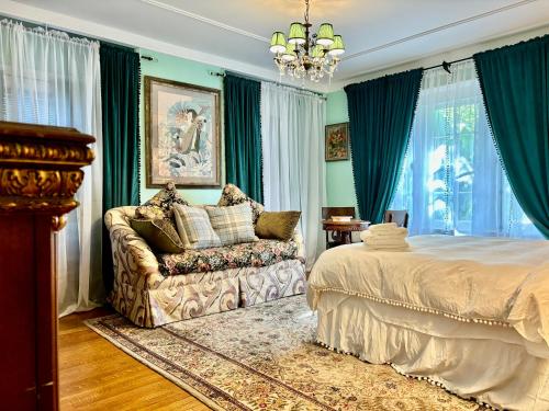 a bedroom with a bed and a chair and a chandelier at Hollywood Home in Los Angeles