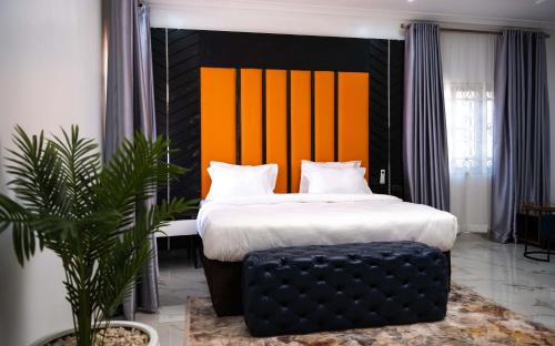 a bedroom with a bed with an orange and black headboard at Duplex16 in Enugu
