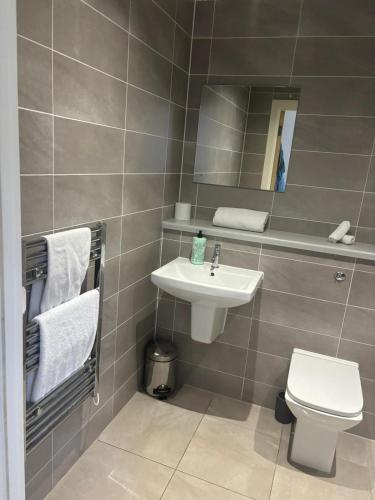 a bathroom with a sink and a toilet and a mirror at Media City Salford Quays in Manchester