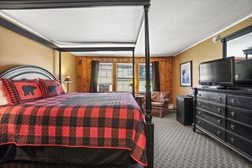 1 dormitorio con 1 cama y TV de pantalla plana en Whitney's Inn, en Jackson