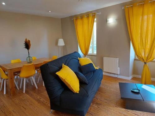 un salon avec un canapé bleu et une table dans l'établissement MONTALIEU SEJOUR Duplex Tournesol, prox CNPE Bugey, PIPA, vallée Bleue, à Montalieu-Vercieu
