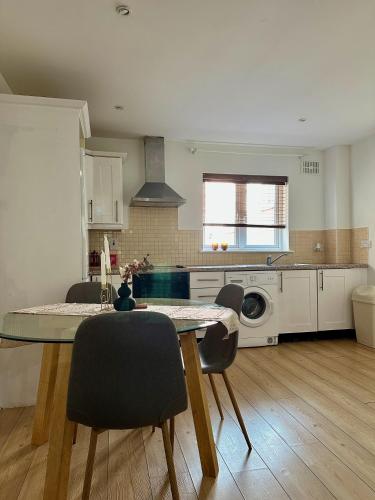 Wellington Duplex Apartment في واتيرفورد: مطبخ مع طاولة وكراسي في غرفة