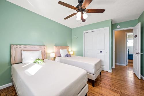 two beds in a room with green walls and a ceiling fan at 6 Min to Ark, Free Covered Parking, Deck and Grill in Williamstown