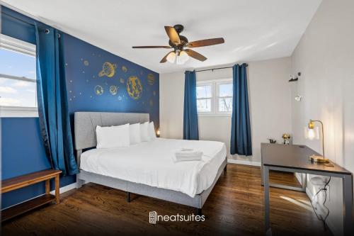 a bedroom with a bed with blue walls and a ceiling fan at 6 Min to Ark, Free Covered Parking, Deck and Grill in Williamstown