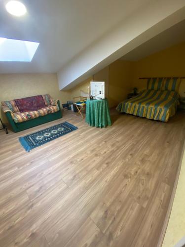 Cette chambre comprend un lit, un canapé et une table. dans l'établissement Maison de campagne, à Saint-Martin-du-Puy