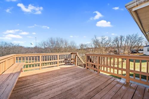 a large wooden deck with a view of a field at Cozy Brick Cottage near Ark in Williamstown