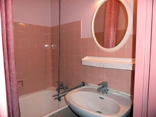 une salle de bain avec un lavabo, une baignoire et un miroir dans l'établissement Studio les Chardonnettes, à Saint-Gilles-Croix-de-Vie