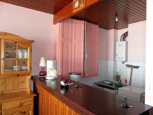 une cuisine avec des placards roses et un comptoir dans l'établissement Studio les Chardonnettes, à Saint-Gilles-Croix-de-Vie