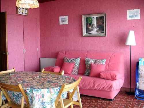 un salon rose avec un canapé rose et une table dans l'établissement Studio les Chardonnettes, à Saint-Gilles-Croix-de-Vie