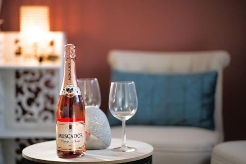 - une bouteille de champagne et 2 verres à vin sur une table dans l'établissement Aman Insolite Jacuzzi Parking Free Centre à 5min, à Mulhouse