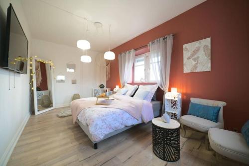 une chambre avec un grand lit et une chaise dans l'établissement Aman Insolite Jacuzzi Parking Free Centre à 5min, à Mulhouse