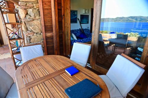 a wooden table and chairs on a porch at Villaggio Est a Capo Coda Cavallo San Teodoro in San Teodoro