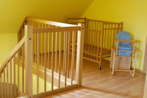 a room with a staircase with a chair and a crib at Apartment Maat in Donovaly