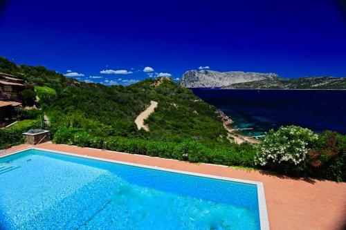 a swimming pool with a view of the ocean at Villaggio Est a Capo Coda Cavallo San Teodoro in San Teodoro