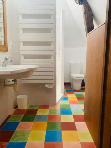 un sol coloré dans une salle de bain avec un lavabo et des toilettes dans l'établissement Gîte vallée des 5 châteaux*climatisation, à Saint-Vincent-de-Cosse