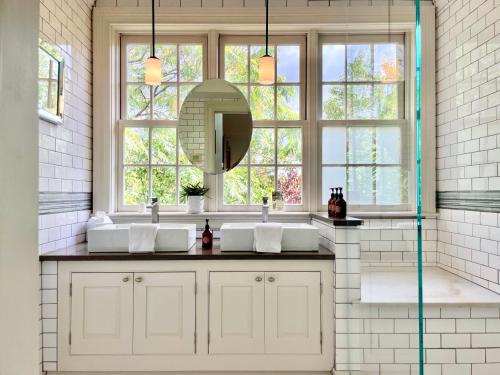 baño con 2 lavabos y ventana grande en Wm. Farmer and Sons, en Hudson