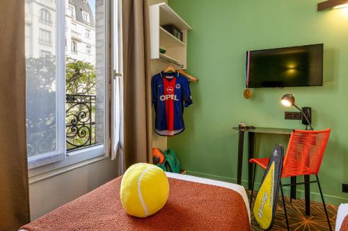 a room with a football jersey hanging on the wall at Hotel Olympic Paris Boulogne by Patrick Hayat in Boulogne-Billancourt