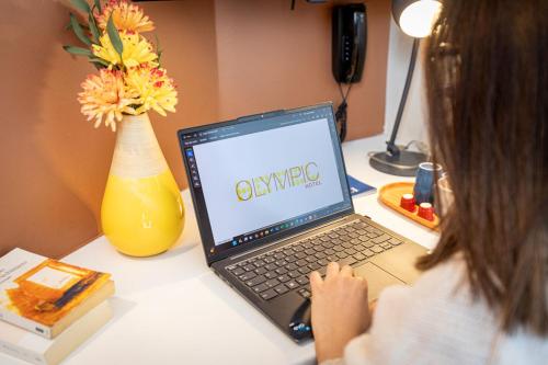 a girl sitting at a desk using a laptop computer at Hotel Olympic Paris Boulogne by Patrick Hayat in Boulogne-Billancourt