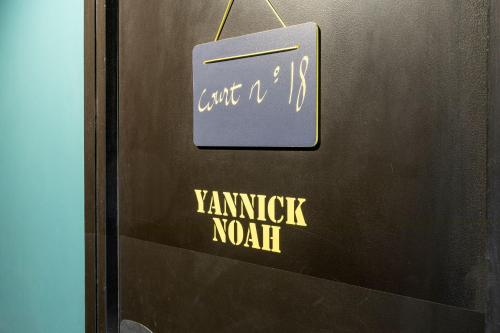 a door with a sign that says yanzik north at Hotel Olympic Paris Boulogne by Patrick Hayat in Boulogne-Billancourt