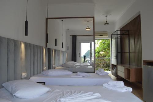 1 dormitorio con 3 camas y espejo en Velco BB Himara, en Himare