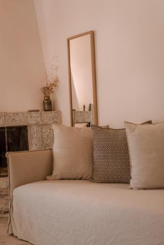a couch with pillows in a living room with a mirror at Alika Resort in Álika
