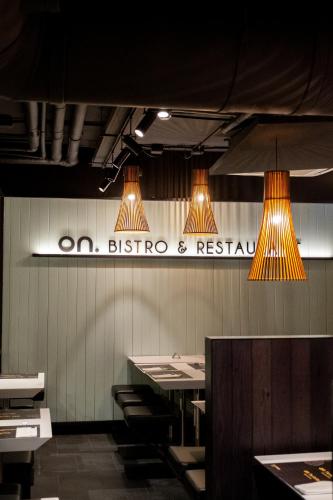 a restaurant with two lights and a sign on the wall at Onmood Cala Ratjada - Bed & Brunch in Cala Ratjada