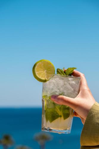 a hand holding a drink with a lime on it at Onmood Cala Ratjada - Bed & Brunch in Cala Ratjada