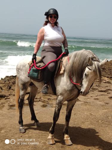 a woman riding a horse on the beach at Riad & Restaurant Ocean Beach Douira in Agadir