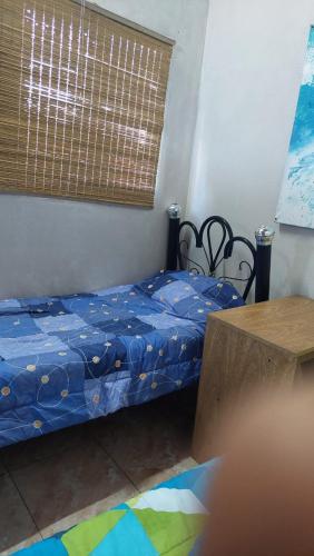 a small bedroom with a bed and a table at LA CASA DE CLAU in Sarandí