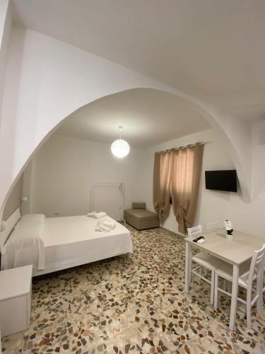 a bedroom with a bed and a desk and a table at Da Peppino e Nicchella in Marina di Camerota