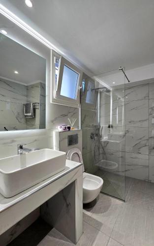 a bathroom with a sink and a toilet and a shower at Margaret House in Zakynthos