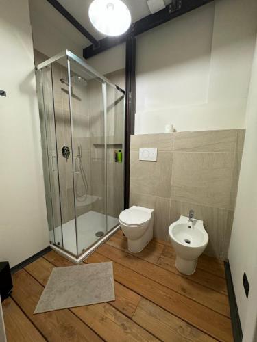 a bathroom with a shower and a toilet and a sink at Ostello Loft La Fabbrica in Settimo Torinese