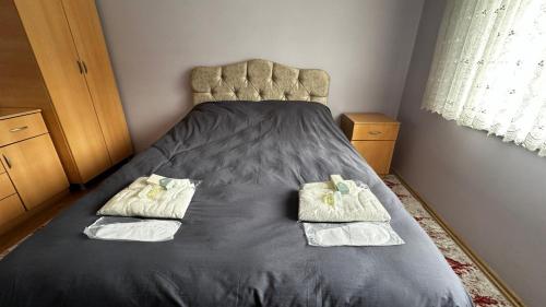 een slaapkamer met een bed met twee handdoeken erop bij Uçmakdere Pansiyon in Şarköy