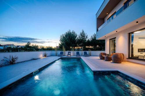 een zwembad in de achtertuin van een huis bij Villa Karlo ZadarVillas in Glavan